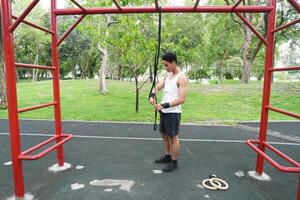 Asian man practicing gymnastics doing gymnastics bar and hoop exercises and stretching and resting for sports. photo
