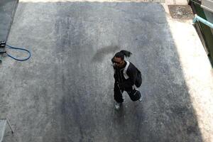 ASian man is dancing in hip hop style at outdoor space. Professional solo dancer is performing in public area. photo