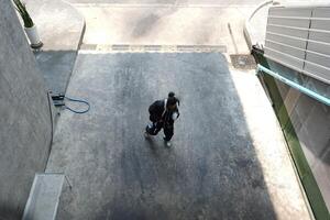 ASian man is dancing in hip hop style at outdoor space. Professional solo dancer is performing in public area. photo