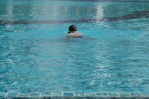 Asian men practicing swimming and preparing to play water polo and stretching and resting for water sports. photo
