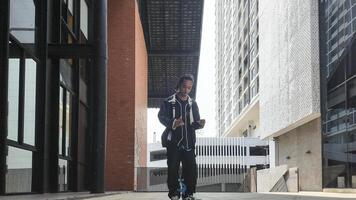 ASian man is dancing in hip hop style at outdoor space. Professional solo dancer is performing in public area. photo