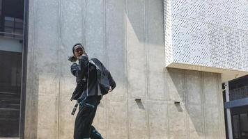 ASian man is dancing in hip hop style at outdoor space. Professional solo dancer is performing in public area. photo