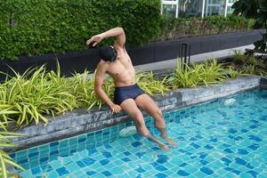 Asian men practicing swimming and preparing to play water polo and stretching and resting for water sports. photo