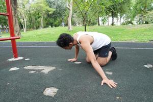 Asian man practicing gymnastics doing gymnastics bar and hoop exercises and stretching and resting for sports. photo