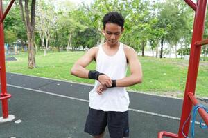 Asian man practicing gymnastics doing gymnastics bar and hoop exercises and stretching and resting for sports. photo