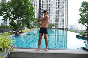 Asian men practicing swimming and preparing to play water polo and stretching and resting for water sports. photo