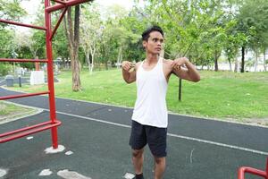 Asian man practicing gymnastics doing gymnastics bar and hoop exercises and stretching and resting for sports. photo