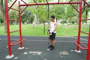 Asian man practicing gymnastics doing gymnastics bar and hoop exercises and stretching and resting for sports. photo
