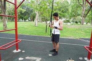 Asian man practicing gymnastics doing gymnastics bar and hoop exercises and stretching and resting for sports. photo