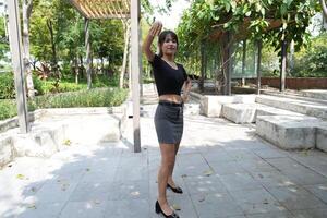 Asian woman dancing in the middle of a park photo