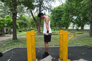 Asian man practicing gymnastics, doing gymnastics bar and hoop exercises and stretching, resting for sports. photo