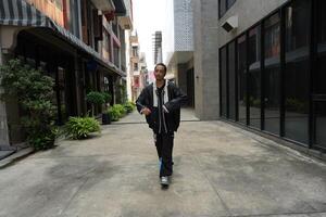ASian man is dancing in hip hop style at outdoor space. Professional solo dancer is performing in public area. photo
