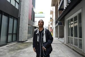ASian man is dancing in hip hop style at outdoor space. Professional solo dancer is performing in public area. photo