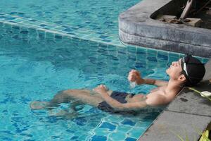 Asian men practicing swimming and preparing to play water polo and stretching and resting for water sports. photo