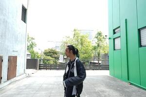 ASian man is dancing in hip hop style at outdoor space. Professional solo dancer is performing in public area. photo