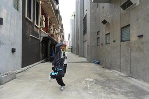 ASian man is dancing in hip hop style at outdoor space. Professional solo dancer is performing in public area. photo