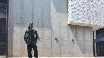 ASian man is dancing in hip hop style at outdoor space. Professional solo dancer is performing in public area. photo