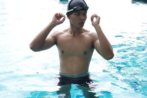 Asian men practicing swimming and preparing to play water polo and stretching and resting for water sports. photo