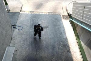 ASian man is dancing in hip hop style at outdoor space. Professional solo dancer is performing in public area. photo