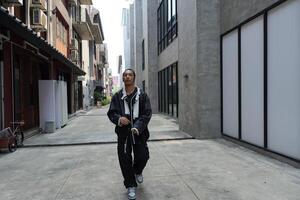 ASian man is dancing in hip hop style at outdoor space. Professional solo dancer is performing in public area. photo