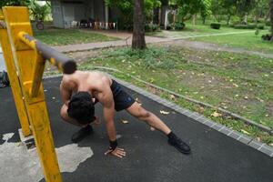 Asian man practicing gymnastics, doing gymnastics bar and hoop exercises and stretching, resting for sports. photo