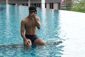 Asian men practicing swimming and preparing to play water polo and stretching and resting for water sports. photo