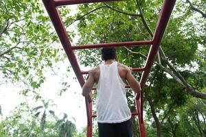 Asian man practicing gymnastics, doing gymnastics bar and hoop exercises and stretching, resting for sports. photo
