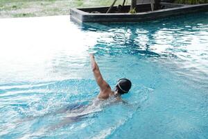 Asian men practicing swimming and preparing to play water polo and stretching and resting for water sports. photo