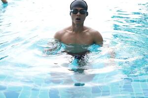 Asian men practicing swimming and preparing to play water polo and stretching and resting for water sports. photo