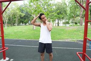Asian man practicing gymnastics doing gymnastics bar and hoop exercises and stretching and resting for sports. photo
