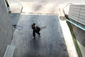 ASian man is dancing in hip hop style at outdoor space. Professional solo dancer is performing in public area. photo