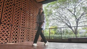 Asian girl dances freestyle hip-hop in an open space. photo