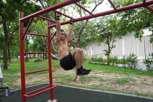 Asian man practicing gymnastics, doing gymnastics bar and hoop exercises and stretching, resting for sports. photo