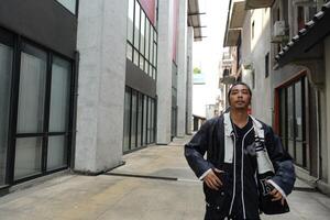 ASian man is dancing in hip hop style at outdoor space. Professional solo dancer is performing in public area. photo