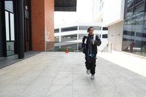 ASian man is dancing in hip hop style at outdoor space. Professional solo dancer is performing in public area. photo