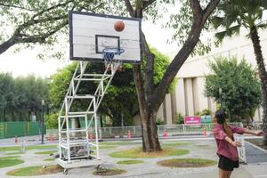 The male and female basketball players practice using the ball in the park court diligently and happily. photo