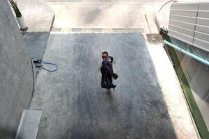 ASian man is dancing in hip hop style at outdoor space. Professional solo dancer is performing in public area. photo