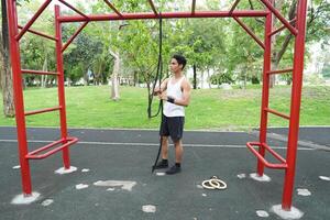 Asian man practicing gymnastics doing gymnastics bar and hoop exercises and stretching and resting for sports. photo