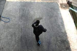 ASian man is dancing in hip hop style at outdoor space. Professional solo dancer is performing in public area. photo