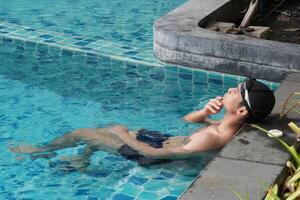 Asian men practicing swimming and preparing to play water polo and stretching and resting for water sports. photo