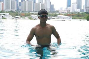 Asian men practicing swimming and preparing to play water polo and stretching and resting for water sports. photo