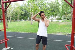 Asian man practicing gymnastics doing gymnastics bar and hoop exercises and stretching and resting for sports. photo