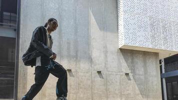 ASian man is dancing in hip hop style at outdoor space. Professional solo dancer is performing in public area. photo