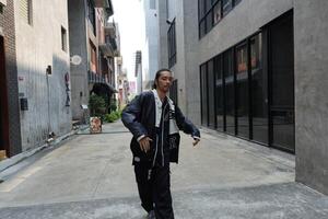 ASian man is dancing in hip hop style at outdoor space. Professional solo dancer is performing in public area. photo