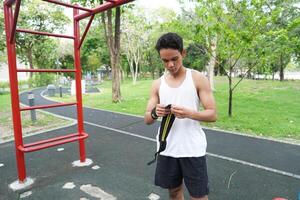 Asian man practicing gymnastics doing gymnastics bar and hoop exercises and stretching and resting for sports. photo