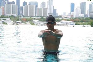 Asian men practicing swimming and preparing to play water polo and stretching and resting for water sports. photo