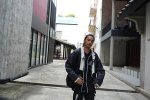 ASian man is dancing in hip hop style at outdoor space. Professional solo dancer is performing in public area. photo