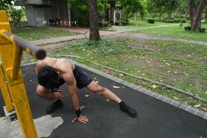 Asian man practicing gymnastics, doing gymnastics bar and hoop exercises and stretching, resting for sports. photo