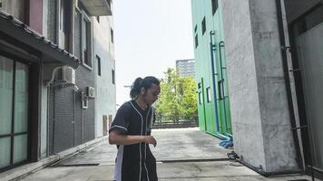 ASian man is dancing in hip hop style at outdoor space. Professional solo dancer is performing in public area. photo