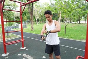 Asian man practicing gymnastics doing gymnastics bar and hoop exercises and stretching and resting for sports. photo